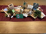 Das Foto zeigt auf einer weinroten Decke die von Lehrkräften für andere Lehrkräfte gefertigten Adventsgeschenke (Dezember 2023).
