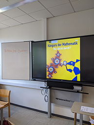 Das Foto zeigt einen Klassenraum mit dem Logo des Wettbewerbs.