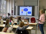 Das Foto zeigt einen Schnupperunterricht am TGG; eine Lehrerin unterrichtet Grundschülerinnen in einem Chemie-Fachraum.