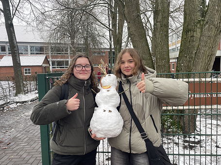 Das Foto zeigt zwei Schülerinnen des TGG mit dem von ihnen gebauten Schnee (Dezember 2023).