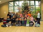 Foto der 5b vor dem von ihr geschmückten Weihnachtsbaum im Foyer des TGG