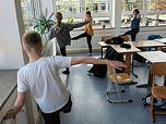 Das Foto zeigt vier Schülerinnen und Schüler der 6a bei Ballettübungen im Klassenraum (Mai 2023).